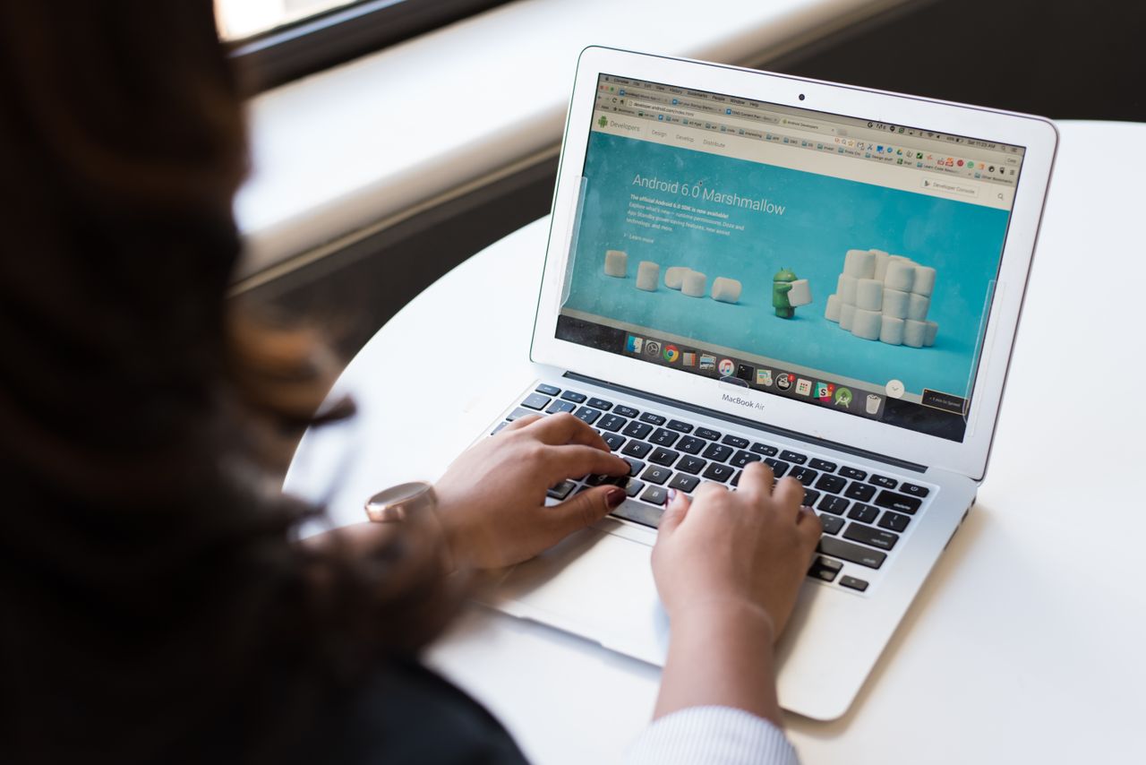 our-story Businesswoman working on laptop with Android 6.0 Marshmallow webpage open.